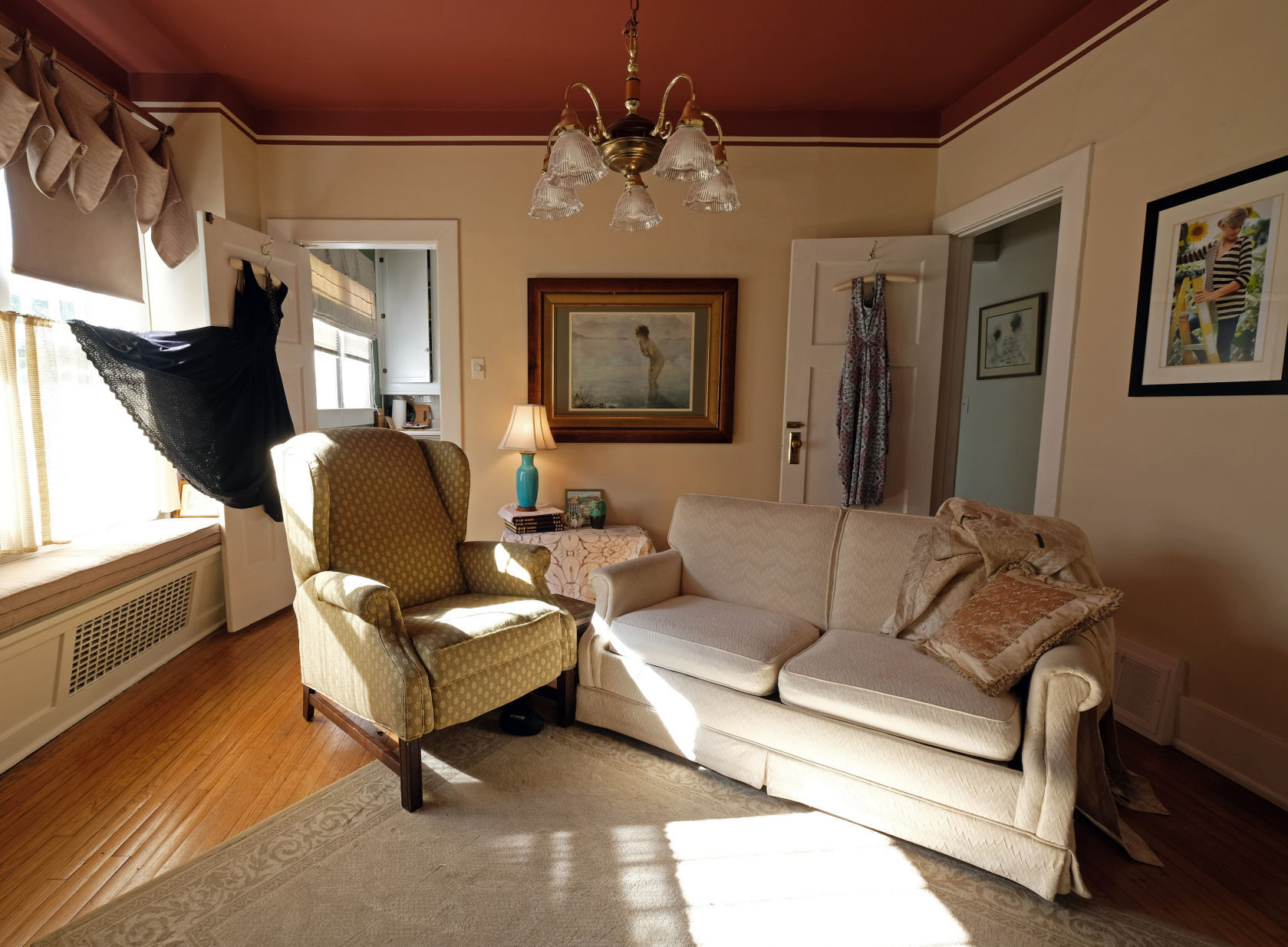 White, flowing curtains frame the windows and delightful vintage decor is artfully arranged in the well-appointed room.